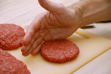 Sådan skal du forme en hakkebøf. Støt kanten af bøffen med den ene hånd, mens du med fingrene på den anden hånd trykker din hakkebøf rund ud til kanten. Foto: Guffeliguf.dk.