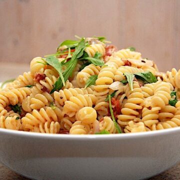 Billede af pasta med rucola, tomat og bacon.