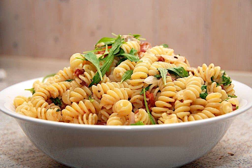 Billede af pasta med rucola, tomat og bacon.