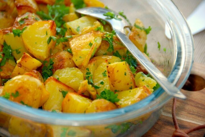 gode og nemme ovnstegte persillekartofler, der smager super godt til blandt andet frikadeller. Kartoflerne steges i ovnen, og vendes efterfølgende med persille. Foto: Guffeliguf.dk.