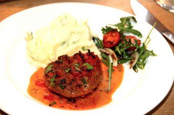 Sådan anretter du hakkebøffer i fad med peberflødesauce, som serveres med kartoffelmos og tomatsalat. Foto: Madensverden.dk.