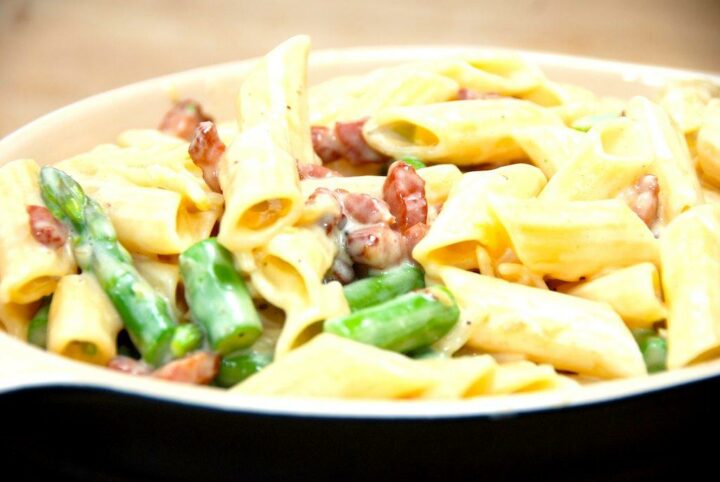 Pasta penne med fløde og bacon er en meget simpel, men særdeles lækker pastaret, der også indeholder grønne asparges. Fløden tyknes ved hjælp af pasteuriserede æggeblommer. Foto: Guffeliguf.dk.