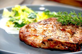 Grillede koteletter med ben og flødestuvet savoykål er god sommermad, hvor kålen stuves i en madlavningsfløde. Foto: Madensverden.dk.