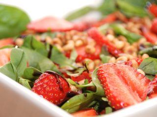 En virkelig lækker jordbærsalat, der er en salat med jordbær, en napolitana salatblanding og ristede pinjekerner.En rigtig sommersalat. Foto: Madensverden.dk.