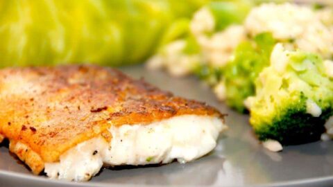 En lækker og pandestegt fisk med skind, der serveres med broccoli risotto og dampet spidskål. Her er der stegt en kuller, men du kan også bruge en torsk eller lignende. Foto: Madensverden.dk.