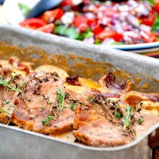 Fadkoteletter med kartofler, løg og flødesovs, der her serveres med en frisk spinatsalat med tomat og rødløg. Foto: Madensverden.dk.