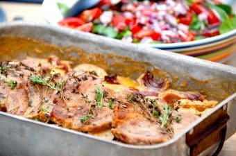 Fadkoteletter med kartofler, løg og flødesovs, der her serveres med en frisk spinatsalat med tomat og rødløg. Foto: Madensverden.dk.
