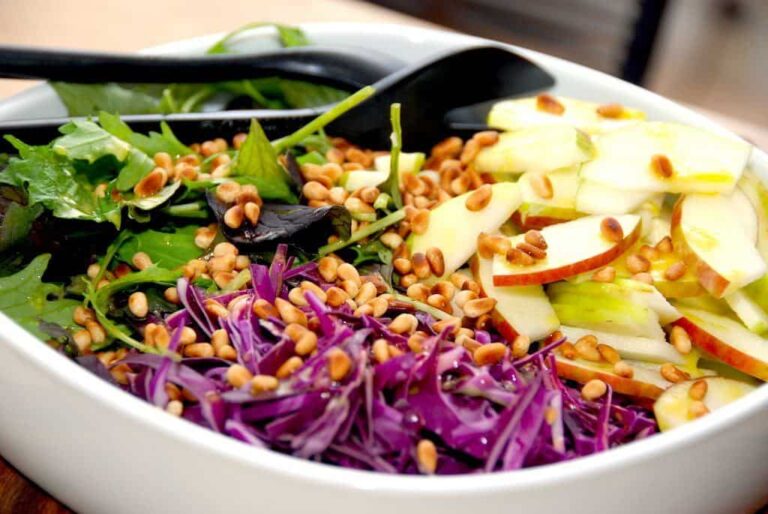 Se lige denne lækre salat med æble, rød spidskål og en napolitana blanding, der dryppes med en lække dressing og pyntes med ristede pinjekerner. Foto: Madensverden.dk.