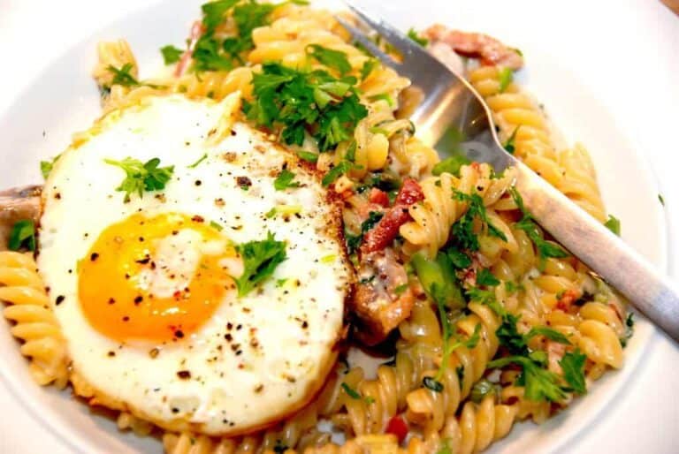 Pasta med spejlæg, hvor spejlægget anrettet ovenpå pastaskruerne, der er vendt i en lækker flødesovs. Det er en nem og meget lækker pastaret. Foto: Madensverden.dk.