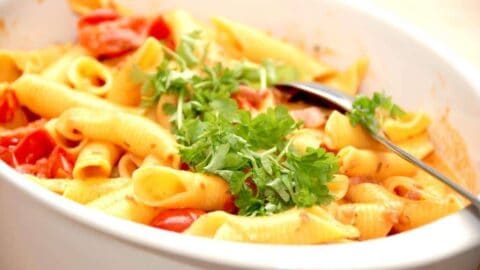 En super lækker og nem pasta opskrift med bacon og cherrytomater på dåse, der koges med lidt fløde. Pasta vendes i og der pyntes med lidt persille. Foto: Madensverden.dk.