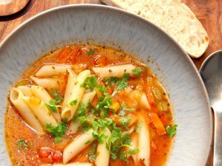 En rigtig italiensk pasta suppe, der laves på en bund af hvidløg og forårsløg, samt gulerødder og bladselleri. Suppen koges med bouillon og tomat, inden pastaen til sidst vendes i sammen med persille. Nyd pasta suppen med friskbagt brød. Foto: Madensverden.dk.