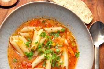 En rigtig italiensk pasta suppe, der laves på en bund af hvidløg og forårsløg, samt gulerødder og bladselleri. Suppen koges med bouillon og tomat, inden pastaen til sidst vendes i sammen med persille. Nyd pasta suppen med friskbagt brød. Foto: Madensverden.dk.