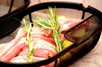 Lav den bedste omgang stegt flæsk og kartofler i rotisserie på grill. Som du kan se på billedet, kan de med fordel lægge nogle kviste rosmarin ned til kartofler og flæskeskiver, hvorefter det hele grilles i en times tid ved indirekte varme. Foto: Madensverden.dk.