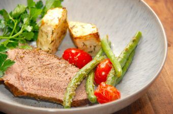 Gammeldags kalvesteg er lækker gæstemad, der ovenikøbet ikke er dyr at lave. Kalvestegen laves af en kalvebov eller kalvetykkam, og steges et par timer i gryde. Serveres med ovnbagt selleri og bagte bønner og tomater. Foto: Madensverden.dk.