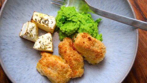 Hjemmelavede fiskenuggets, der laves af torsk, som paneres i mel, æg og rasp. Derefter steges de lækre fiskenuggets i ovnen, og på billedet er de serveret med ærtemos og ovnbagt selleri. Foto: Madensverden.dk.
