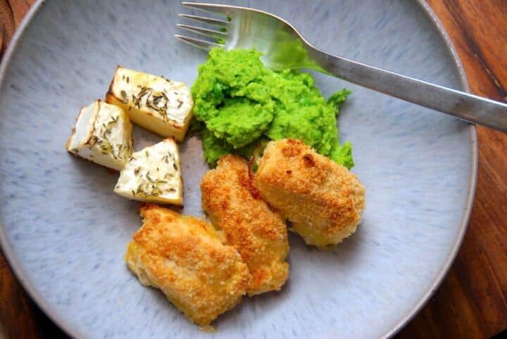 Hjemmelavede fiskenuggets, der laves af torsk, som paneres i mel, æg og rasp. Derefter steges de lækre fiskenuggets i ovnen, og på billedet er de serveret med ærtemos og ovnbagt selleri. Foto: Madensverden.dk.