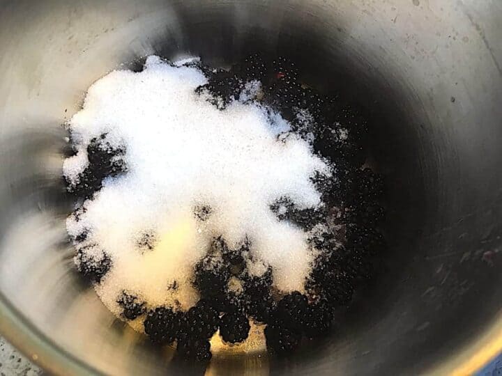 kogning af brombær og sukker til brombærmarmelade