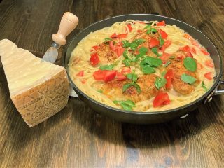 Pasta med hvidvin og en Grana Padano ost ved siden af retten.
