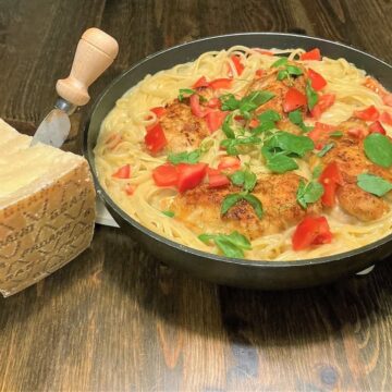 Pasta med hvidvin og en Grana Padano ost ved siden af retten.