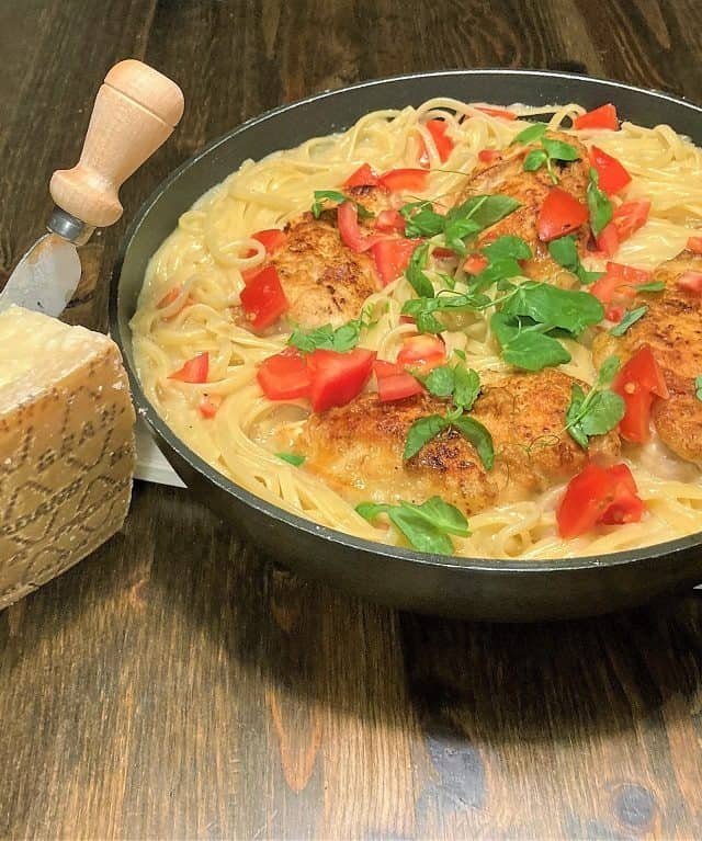 Pasta med hvidvin og en Grana Padano ost ved siden af retten.