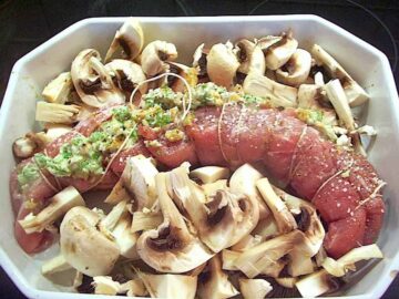 Svinemørbrad fyldt med hvidløgssmør og valnødder er lækker aftensmad, som du også sagtens kan bruge som gæstemad. Her er mørbraden i godt selskab med masser af champignon. Foto: Newyorker By Heart, Madensverden.dk.