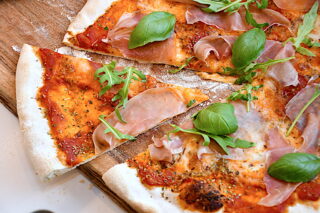 billede med hjemmelavet pizza med tomat, mozzarella og skinke