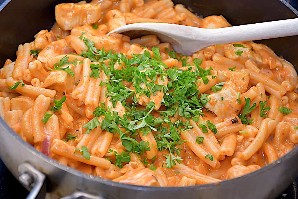 Billede af kylling med pasta i cremet tomatflødesauce.