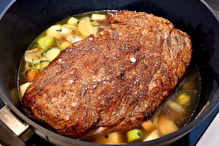 den braiserede nakkefilet på bund af grøntsager i gryden