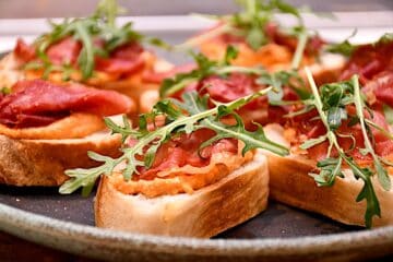 Billede af brød med romesco og bagt serrano.