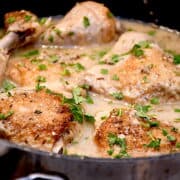 Billede af kyllingelår i cremet rosmarinsauce med mange hvidløgsfed.