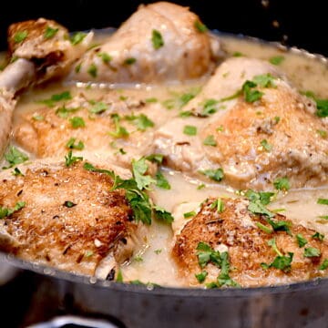 Billede af kyllingelår i cremet rosmarinsauce med mange hvidløgsfed.