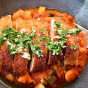 Billede af sprød kylling med hvide bønner i tomatsauce.