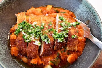 Billede af sprød kylling med hvide bønner i tomatsauce.