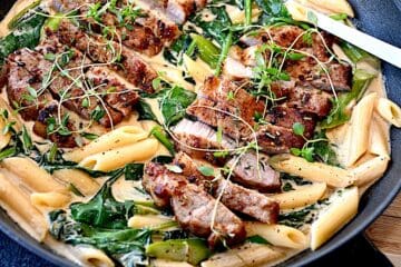 Billede af koteletter med pasta, asparges og spinat i cremet flødesovs.